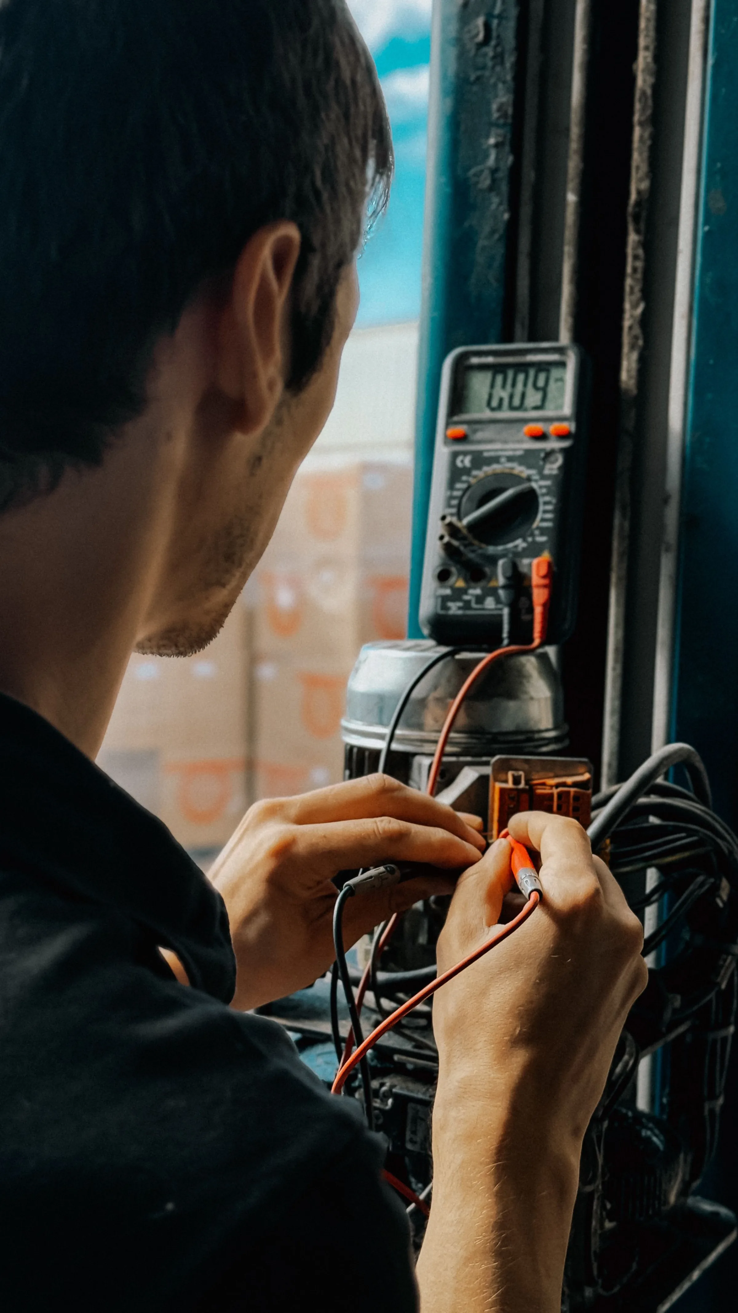 Electrician testing residential wiring with a multimeter